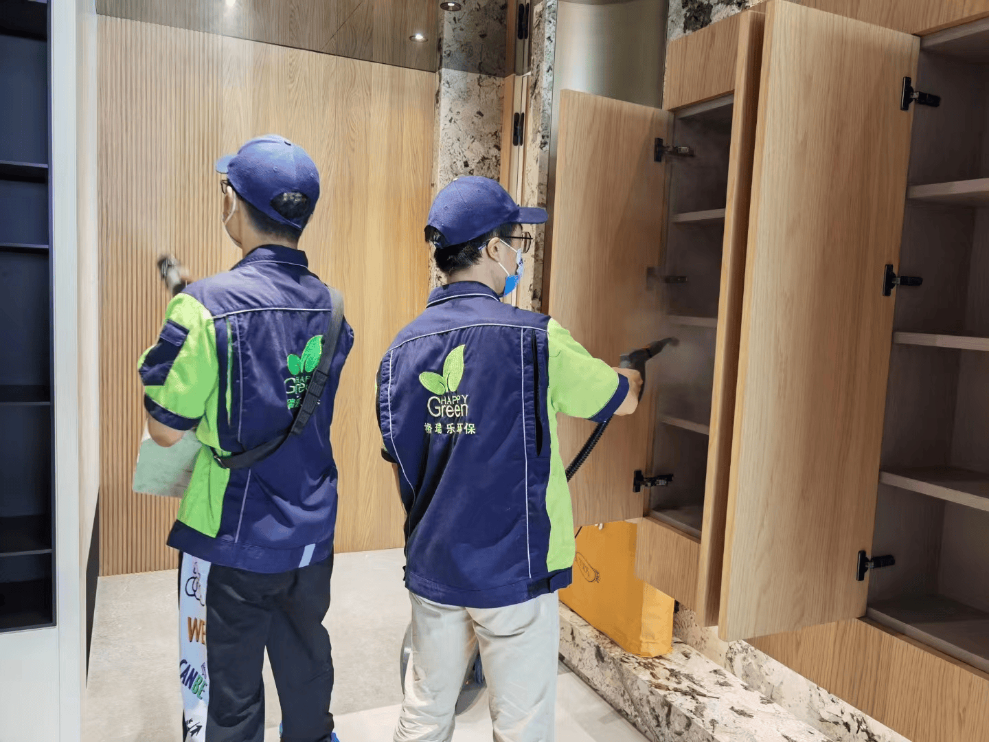 卧室里，工作人员用干净的抹布擦拭衣柜表面，清除施工过程中残留的药剂。